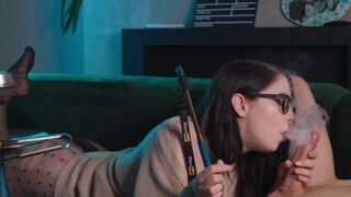 A girl in glasses smokes and sucks cock intensely