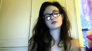 A cute girl in glasses takes off her clothes on webcam