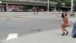 A girl with a beautiful body made an elegant pose in public
