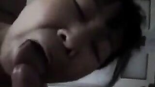 An elderly Chinese woman practices her blowjob skills