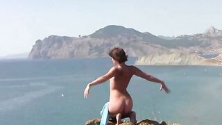A naked girl is sunbathing on the beach with her ass up