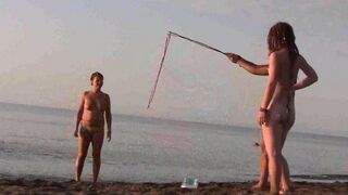 A girl is having fun naked on the sandy coast of the sea