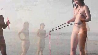 A girl is having fun naked on the sandy coast of the sea