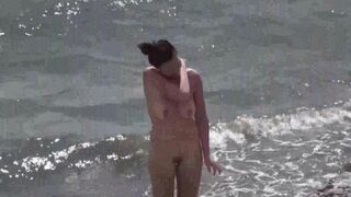 A couple of free-spirited lovers on a nudist beach, enjoying each other