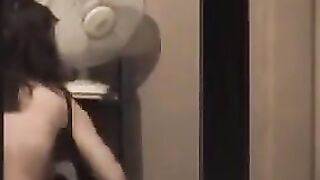 The guy admires himself in the mirror, standing completely naked in front of him