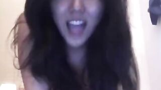 An Asian girl masturbates on her bed and reaches intense orgasm