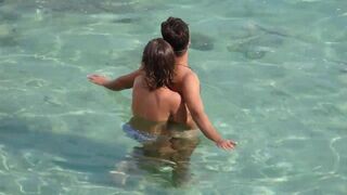 A girl is jerking a guy’s cock while they are underwater