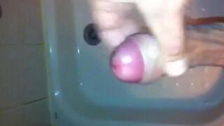 The kid caresses his dick in the shower and comes