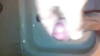 The kid caresses his dick in the shower and comes