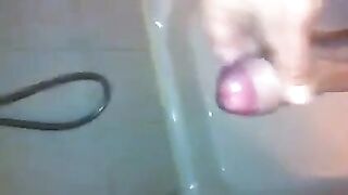 The kid caresses his dick in the shower and comes